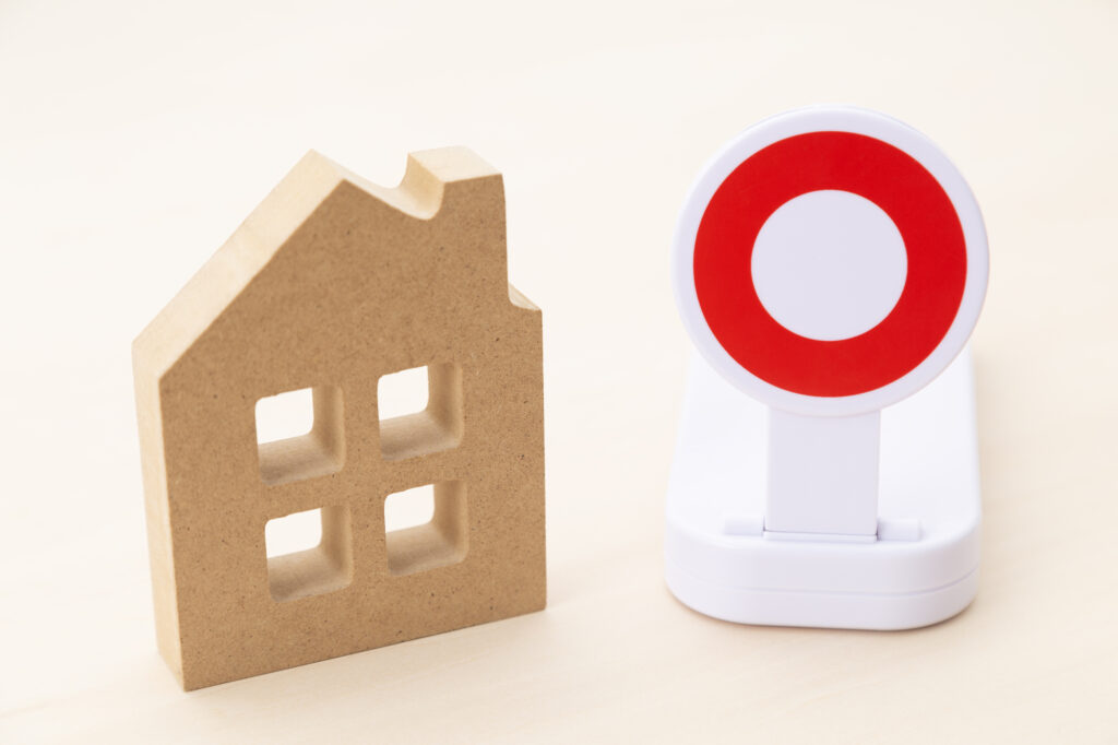住宅購入の判断をイメージした家の模型とチェックマーク